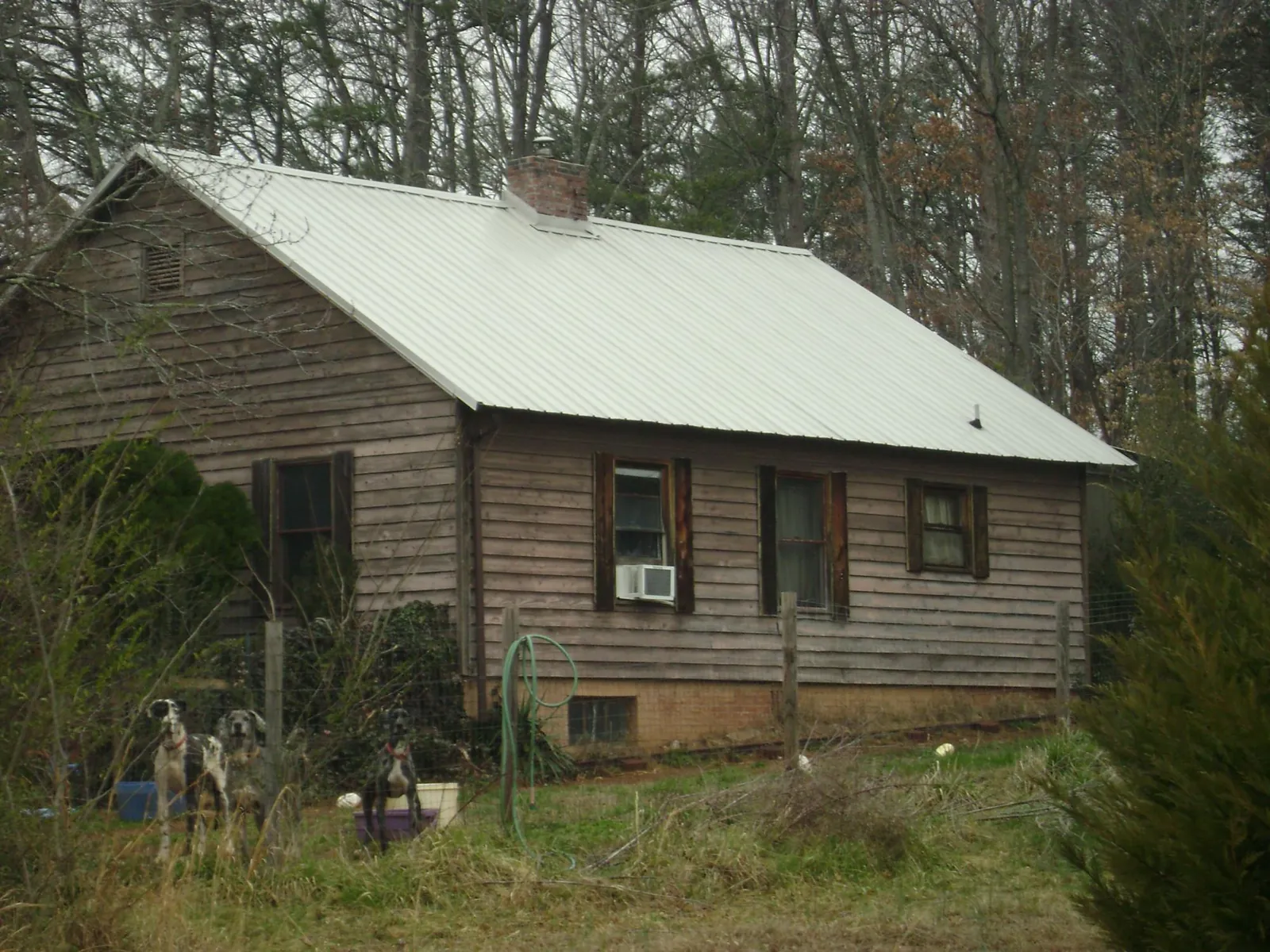White metal roof on an old wood sided farmhouse, from a Metal Roof Installation job in Cost